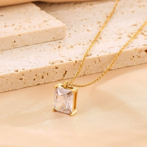 Detailed macro view of a rectangular glass pendant with classic four-prong gold setting