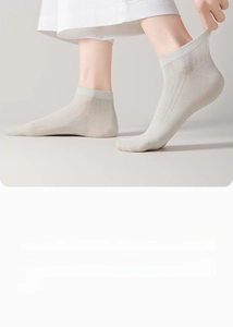 Detail of Morandi gray silk mesh ankle socks showing breathable texture on feet