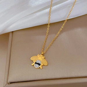 Détail du pendentif abeille dorée avec cristaux noirs et blancs sur chaîne fine