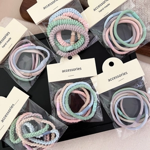 Detailed view of elastic hair ties in pastel macaron colors with woven fabric texture