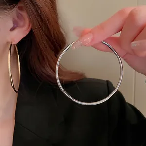 Minimalist oversized metal hoop earrings in polished gold and silver finish