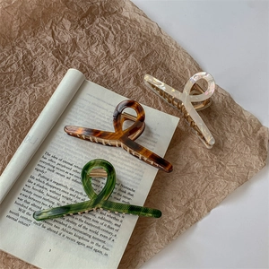 Three-piece set of elegant acetate hair claws in amber, pearl white, and dark green colors