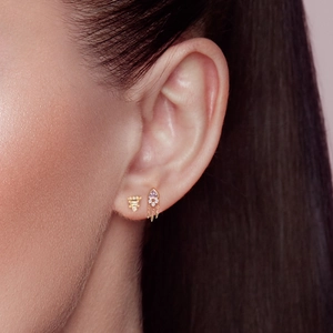 Puce triangle en argent S925 et boucle à pompon rose portées sur l'oreille
