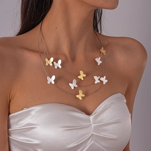Three-layer butterfly necklace in gold and silver finish worn on white satin dress