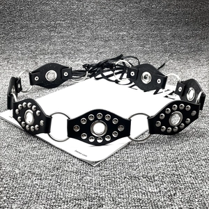 Close-up of Y2K vintage leather belt with silver metal rings and punk rivet details