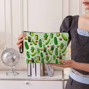 Green toiletry bag with cute cucumber and burger prints held by a person in a modern room