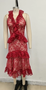 Detail of red lace dress showing intricate hollow-out texture and tiered ruffle accents