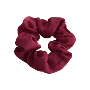 Elegant wine red satin silk scrunchie with soft sheen and pleated texture on white background