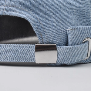 Adjustable back strap of light blue washed denim skull cap with metal buckle closure