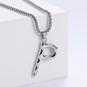 Macro du pendentif lettre P argenté à texture martelée sur une chaîne en acier inoxydable