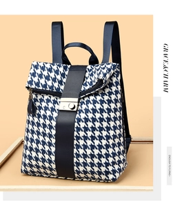 Detail eines blauen Rucksacks mit Hahnentrittmuster, Lederband und silberner Schnalle