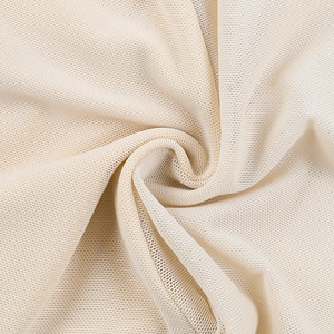 Detailopname van ademende beige mesh-stof met delicate textuur en zachte soepele val