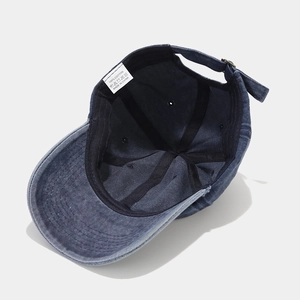 Inside view of washed denim baseball cap with HELLO embroidery and 100% cotton label