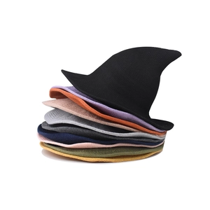 Stacked variety of colorful knitted witch hats in vibrant shades for Halloween