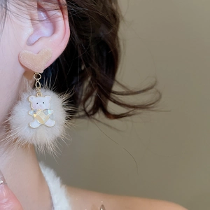 Detailed view of resin bear pendant with fuzzy pompom on elegant heart stud earrings