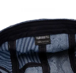 Detail of blue denim newsboy hat interior showing black sweatband and cotton care label