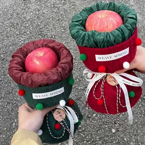 Knitted Christmas apple bouquet bags in red and green with plush pom-poms and ribbon