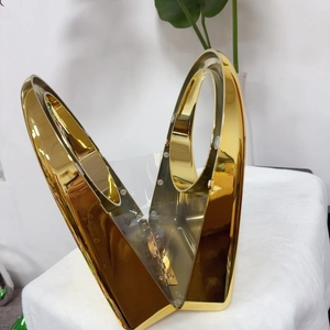 Detail view of a luxury gold metallic geometric evening handbag with a polished mirror finish