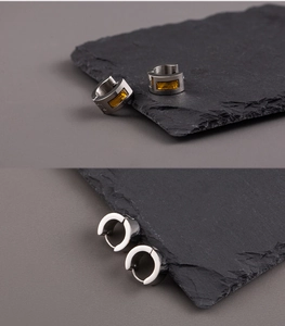 Detailed view of silver titanium steel earrings with yellow rectangular resin inlay