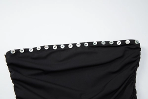 Détail du tissu froncé noir avec des boutons en coquillage blanc sur le bord supérieur