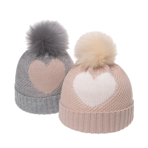 Cozy knit beanies for kids with heart patterns and large fluffy pom-poms for winter warmth