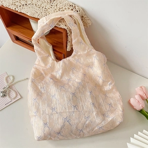 Détail de la texture à nœud floral sur un sac cabas léger en mesh pour femmes