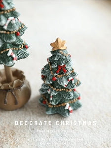 Close-up of mini resin Christmas tree with gold star, red bows and candy canes