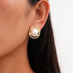 Close-up of model wearing a vintage gold stud earring with a large resin pearl and crystals
