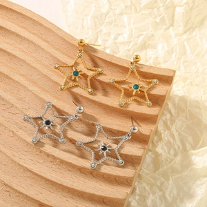 Close-up of star-shaped earrings with rhinestones on a natural textured wood stand