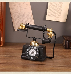 Detail of vintage rotary dial telephone model with bell system logo on wooden table