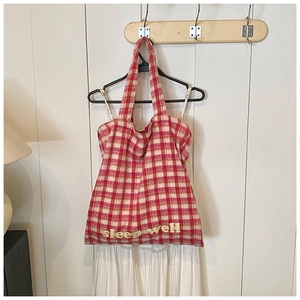 Detail of red and white checkered plush tote bag with Sleep Well 3D embroidery detail
