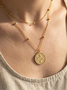 Gros plan du collier double rang avec pendentif œil maléfique doré sur le mannequin