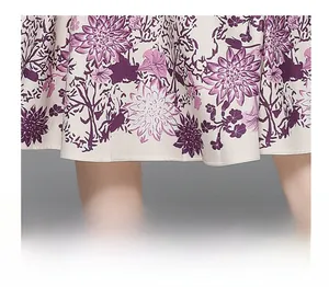 Detail shot of flowy hemline featuring purple floral prints on lightweight fabric