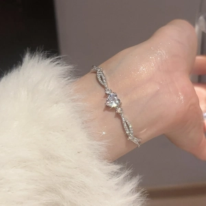 Close-up of elegant silver heart bracelet with sparkling zircons worn by a model