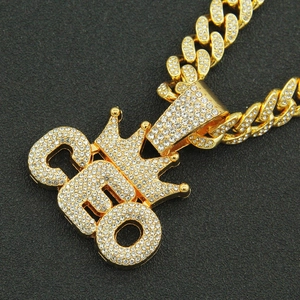 Close-up of golden CEO crown pendant with full diamonds on a chunky Cuban link chain
