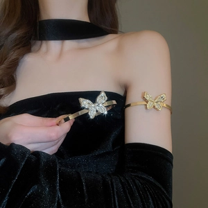 Close-up of sparkling butterfly upper arm cuff with rhinestones on a gold-tone metal band