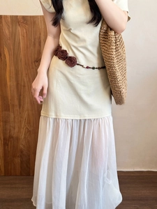 Close-up of a woven waist chain with 3D floral accents on a chiffon pleated dress