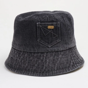 Détail d'un chapeau bob en denim gris foncé avec mini poche et logo métallique doré