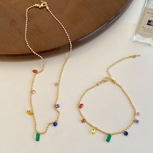 Gold beaded necklace and bracelet set with colorful geometric crystal charms
