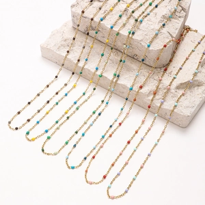 French vintage stainless steel necklaces with colorful enamel beads on a stone display