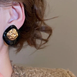 Detail view of vintage geometric stud earring with gold-tone metal and black resin texture