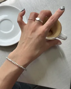 Close-up of minimalist S925 sterling silver block chain bracelet and rings on hand