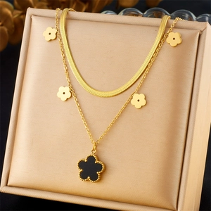 Elegant gold double-layer titanium necklace with black clover pendants in a jewelry box
