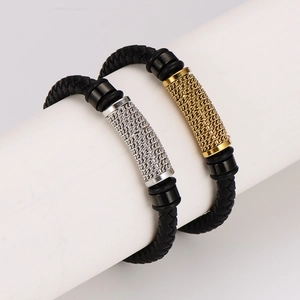 Braided black leather bracelets with gold and silver metal accents on a display stand