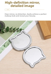 Macro shot of silver metal cat-eared folding makeup mirror with dual high-definition lenses