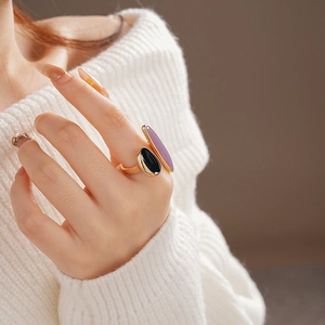 Detail shot of a double oval stone ring with black and purple gems on a gold band