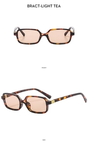 Detail view of tortoiseshell rectangle sunglasses with light tea lenses and metal hinges