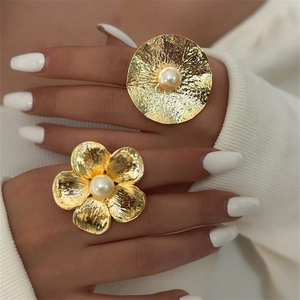 Close-up of vintage gold hammered texture rings with pearls on a model's hand