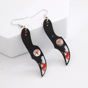 Macro detail of acrylic dagger earrings featuring red blood splatter print for Halloween