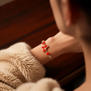 Gros plan du bracelet plaqué or avec breloque animal rouge et accents de cristal